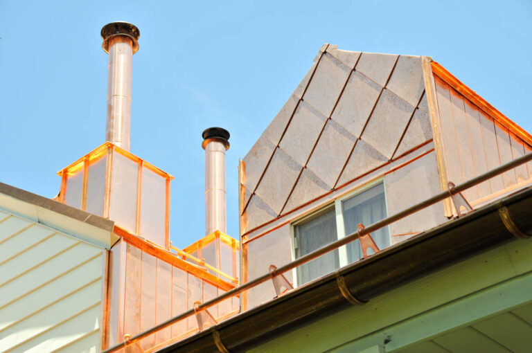 House with shiny copper roof and chimney stacks