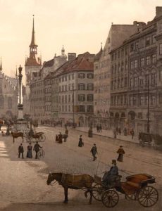 Historic view of Marienplatz in Munich, Germany, circa 1901, showcasing the iconic Neues Rathaus and bustling town square as a symbol of enduring legacy.